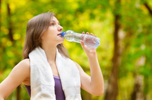 女性のフィットネス運動後の水を飲む — ストック写真