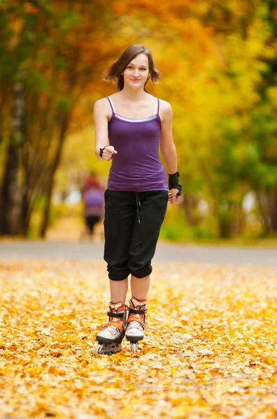 ローラー スケート公園で女性一个年轻的女孩在秋天公园中运行 — ストック写真