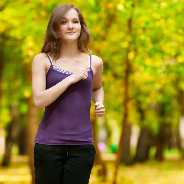 A young girl running in autumn park — Stock Photo, Image