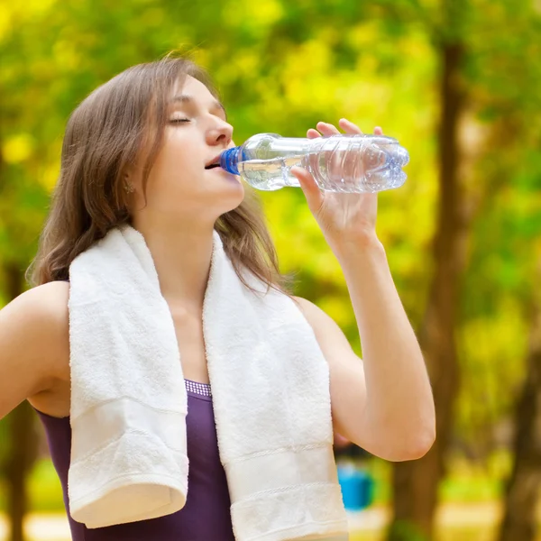 Woman drinking water after fitness exercise — Stock Photo, Image