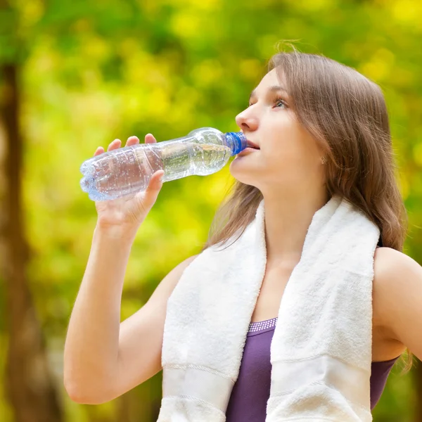 Женщина пьет воду после физических упражнений — стоковое фото
