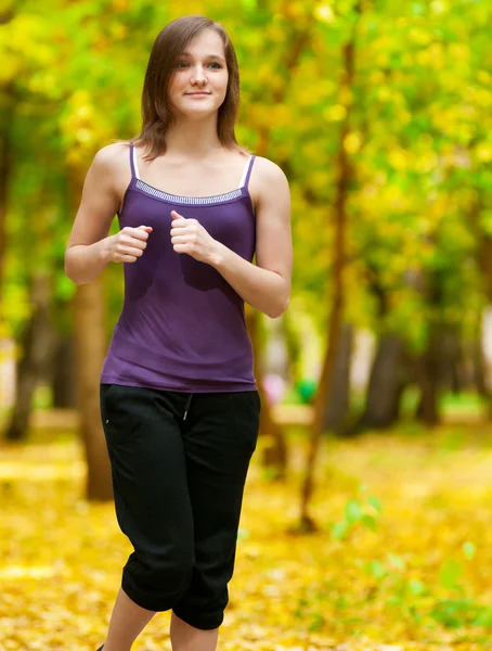 A young girl running in autumn park — Stock Photo, Image