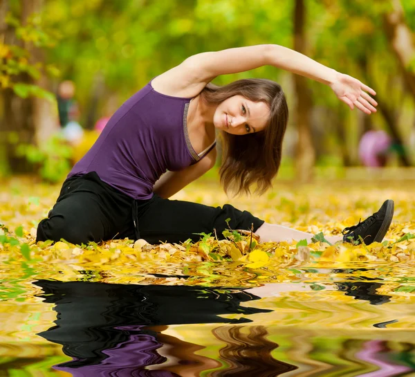 Mujer haciendo ejercicios de yoga en el parque de otoño —  Fotos de Stock