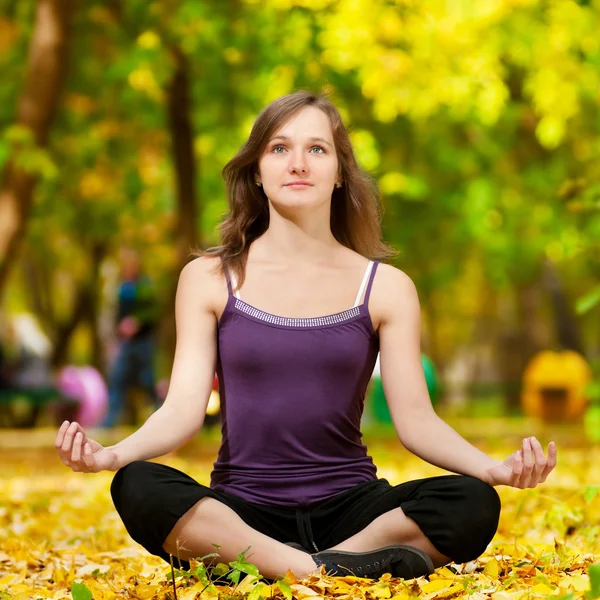 Žena, která dělá cvičení jógy v podzimním parku — Stock fotografie