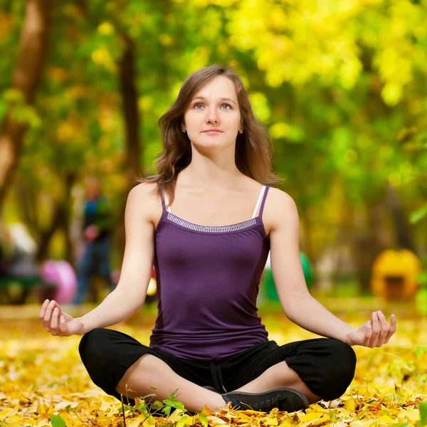 Donna che fa esercizi di yoga nel parco autunnale — Foto Stock