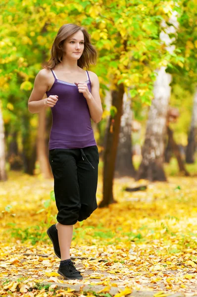 ローラー スケート公園で女性一个年轻的女孩在秋天公园中运行 — 图库照片
