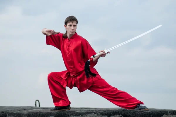 Wushoo hombre en las artes marciales práctica rojo — Stockfoto