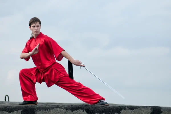 Wushoo hombre en las artes marciales práctica rojo — Stockfoto