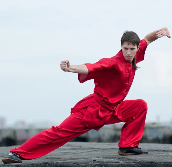 Wushoo hombre en las artes marciales práctica rojo — Stockfoto