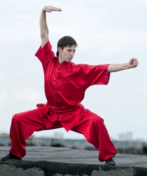 Wushoo hombre en las artes marciales práctica rojo — Stockfoto