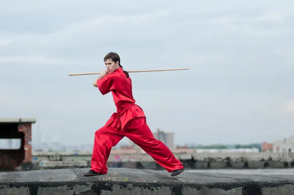 Wushoo hombre en las artes marciales práctica rojo — Stockfoto