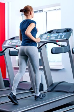 spor salonunda bir makinede çalışan genç bir kadın