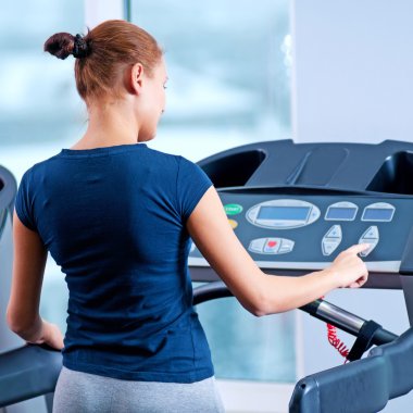 spor salonunda bir makinede çalışan genç bir kadın