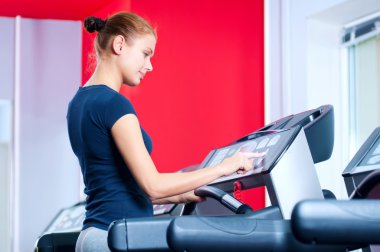 spor salonunda bir makinede çalışan genç bir kadın