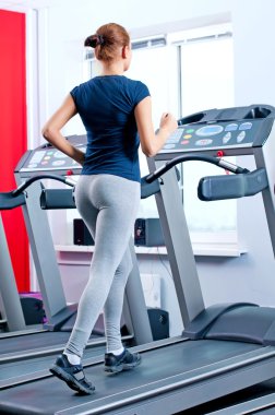 spor salonunda bir makinede çalışan genç bir kadın
