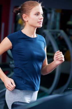 spor salonunda bir makinede çalışan genç bir kadın