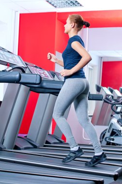 spor salonunda bir makinede çalışan genç bir kadın