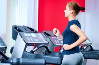spor salonunda bir makinede çalışan genç bir kadın