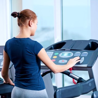 spor salonunda bir makinede çalışan genç bir kadın