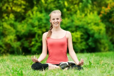 Genç bir kadın esneme egzersizi yapıyor.