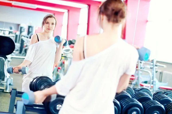 Woman doing splits with weights — Stock Photo, Image