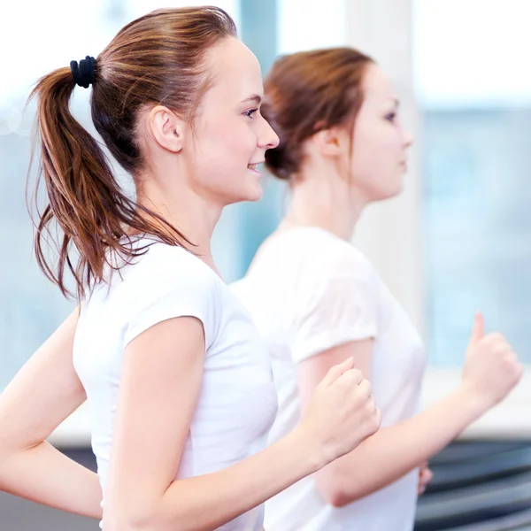 Deux jeunes femmes sportives courent sur la machine — Photo