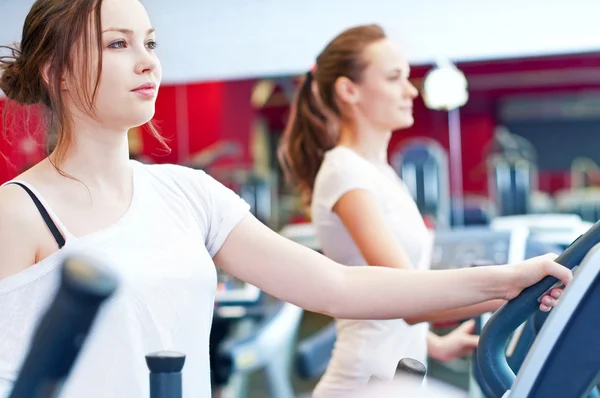 Two young sporty women run on machine — Stock Photo, Image