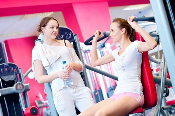 Woman doing splits on machine with weights — Stock Photo, Image