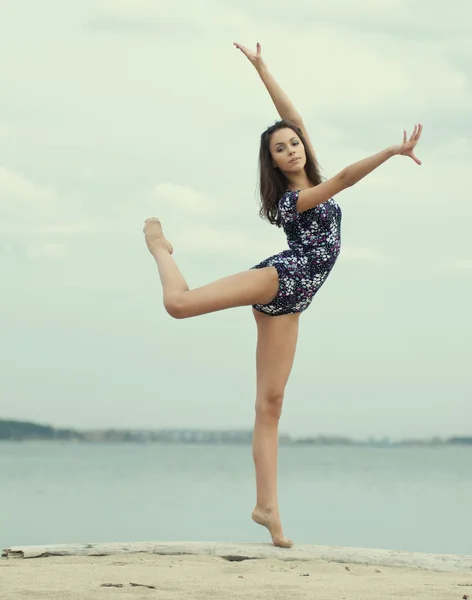 Jovem ginasta menina dança na praia — Fotografia de Stock