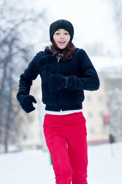 Ung flicka som körs på en kall vinterdag — Stockfoto