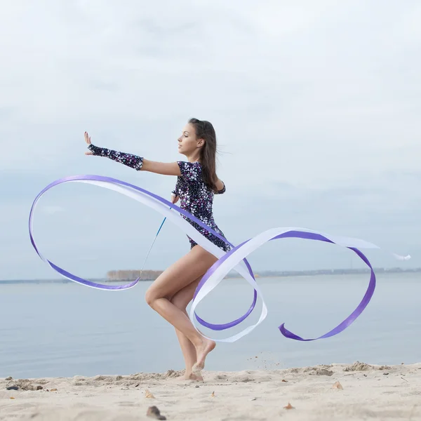 年轻的体操运动员的女孩舞蹈与功能区 — 图库照片