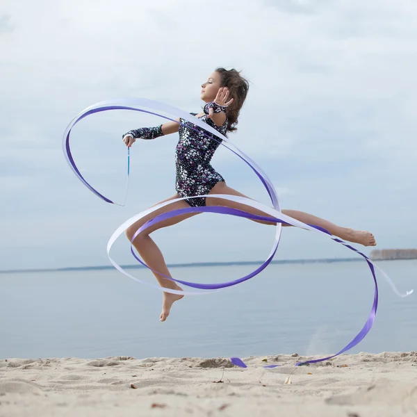 Молодая гимнастка танцует с ленточкой — стоковое фото