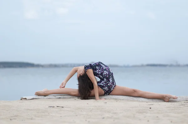 Jovem ginasta menina dança na praia — Fotografia de Stock
