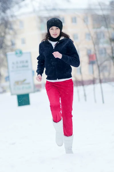 Молодая девушка бежит в холодный зимний день — стоковое фото