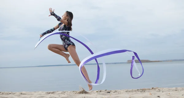 年轻的体操运动员的女孩舞蹈与功能区 — 图库照片