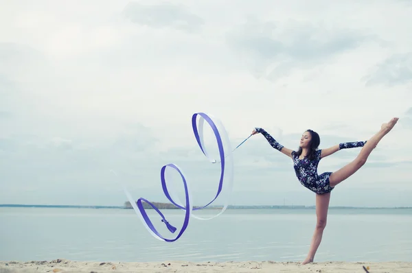 年轻的体操运动员的女孩舞蹈与功能区 — 图库照片