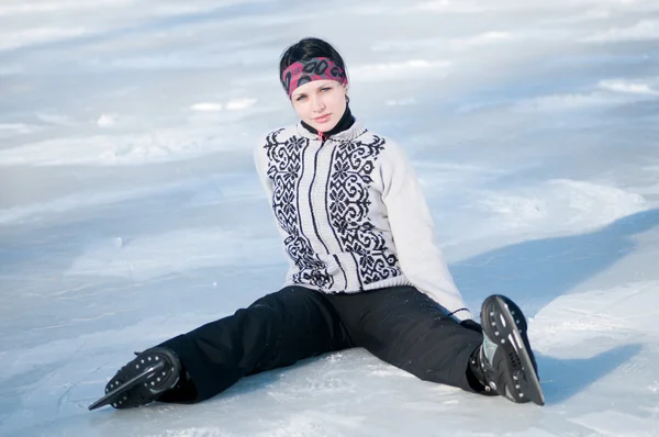 Ice skating kvinna sitter på is — Stockfoto