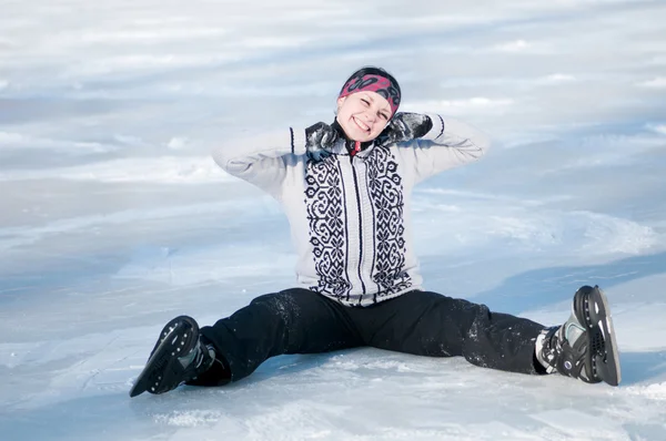 Ice skating woman sitting on ice — Stock Photo, Image