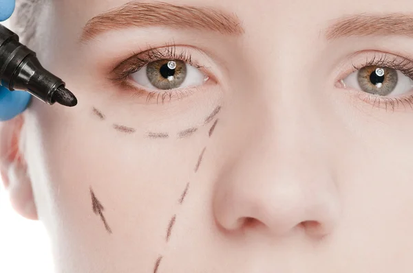 Schoonheidsspecialiste correctie lijnen tekenen op vrouw gezicht — Stockfoto