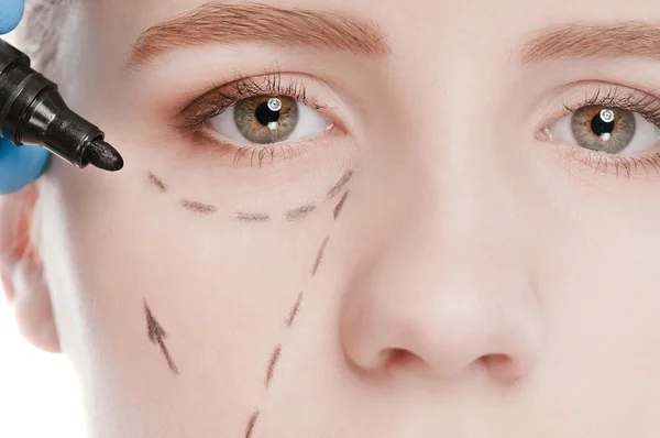 Beautician draw correction lines on woman face — Stock Photo, Image