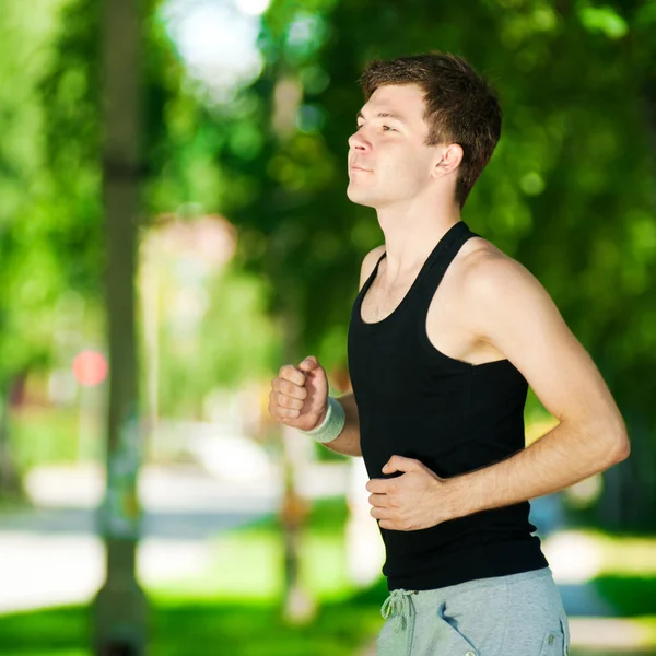 Jonge man joggen in het park — Stockfoto