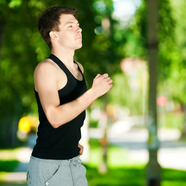 Jonge man joggen in het park — Stockfoto