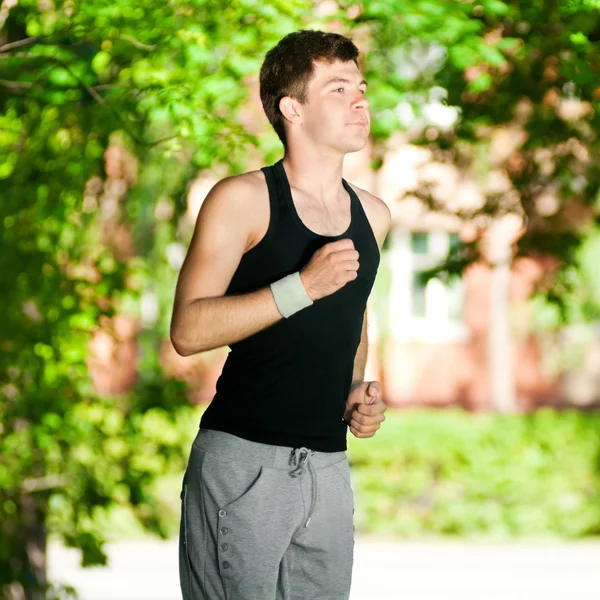 Junger Mann joggt im Park — Stockfoto