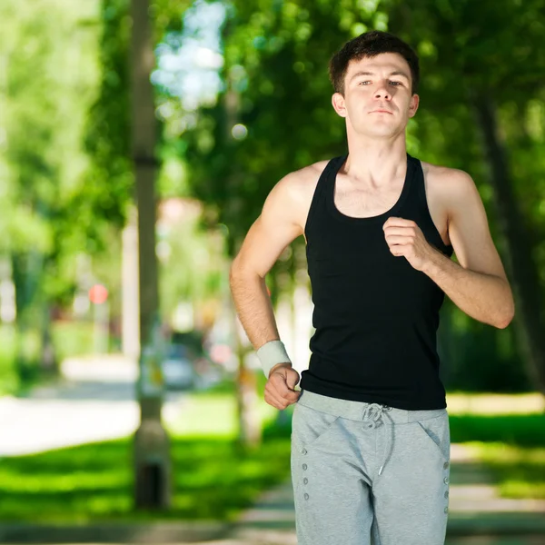 Junger Mann joggt im Park — Stockfoto