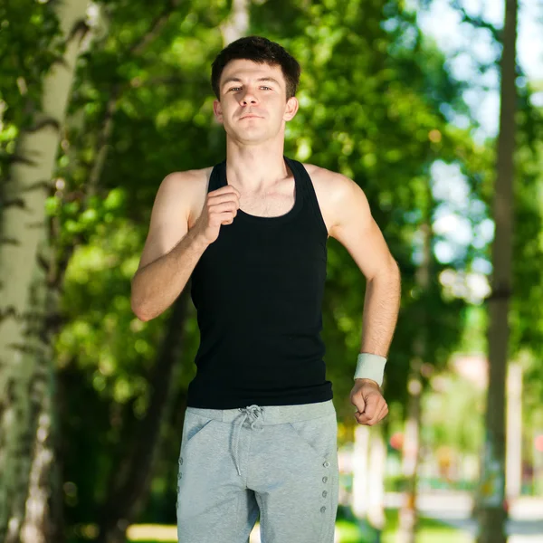 Jonge man joggen in het park — Stockfoto