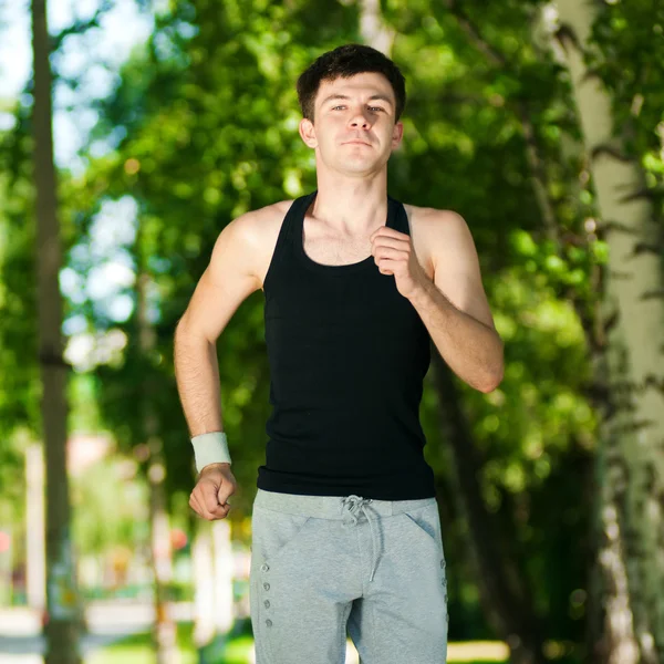 Jeune homme jogging dans le parc — Photo