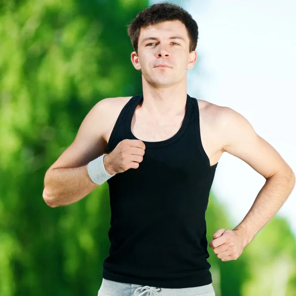 Jonge man joggen in het park — Stockfoto