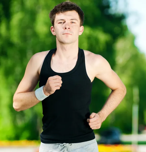 Young man jogging in park — Stock Photo, Image