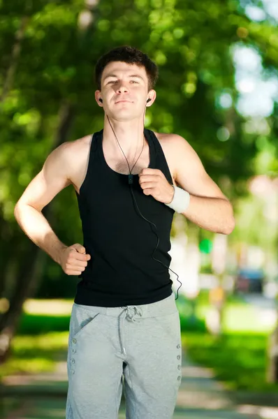 Junger Mann joggt im Park — Stockfoto