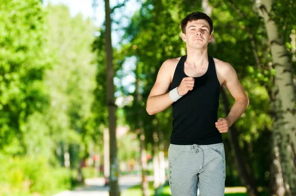 Young man jogging in park — Stock Photo, Image